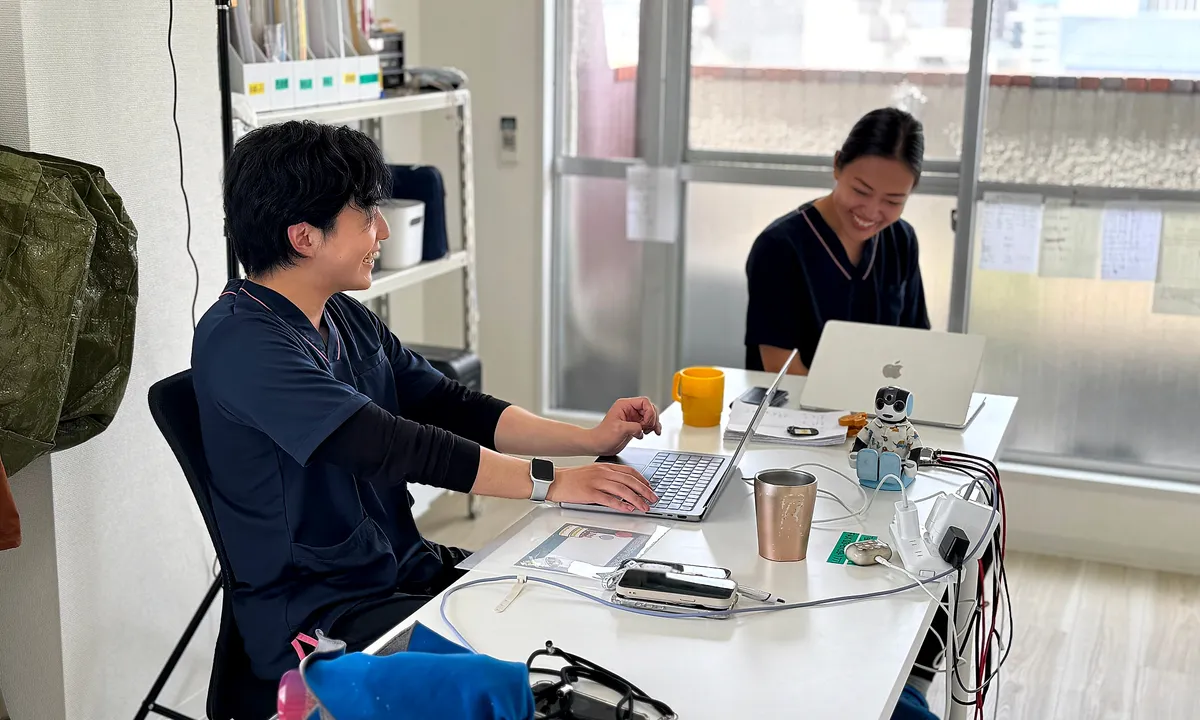 事務所のデスクで記録を進めるスタッフ